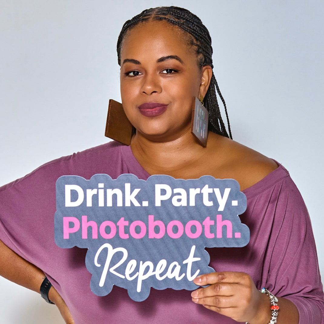 Woman holding a “Drink. Party. Photobooth. Repeat.” photo booth prop sign